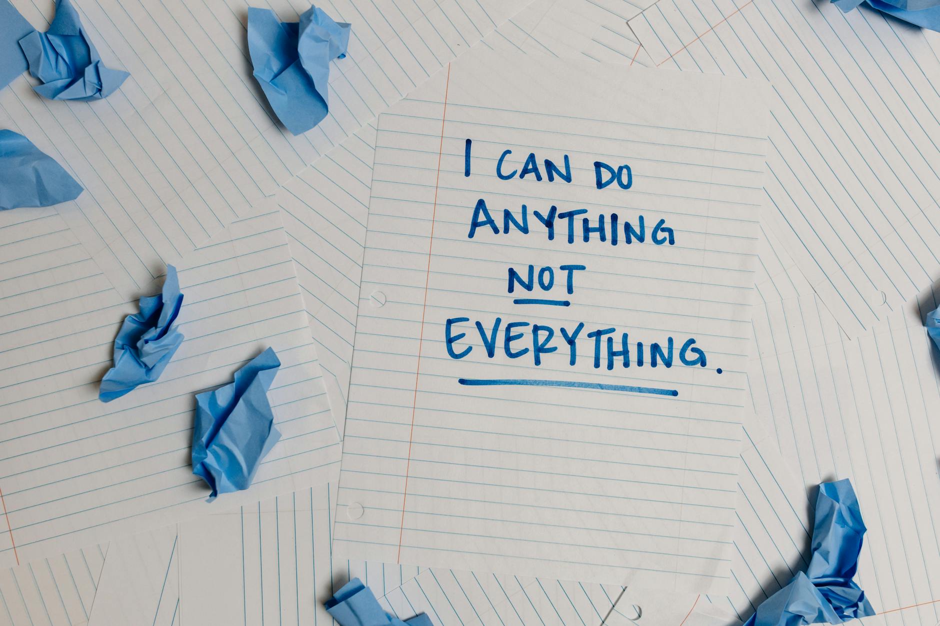 Inspirational note on paper with crumpled blue pages around, ideal for motivation concepts.